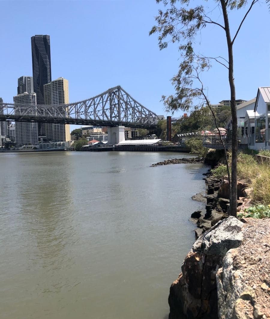 The Brisbane River curving through the city, with the Story Bridge and riverbank buildings beyond.