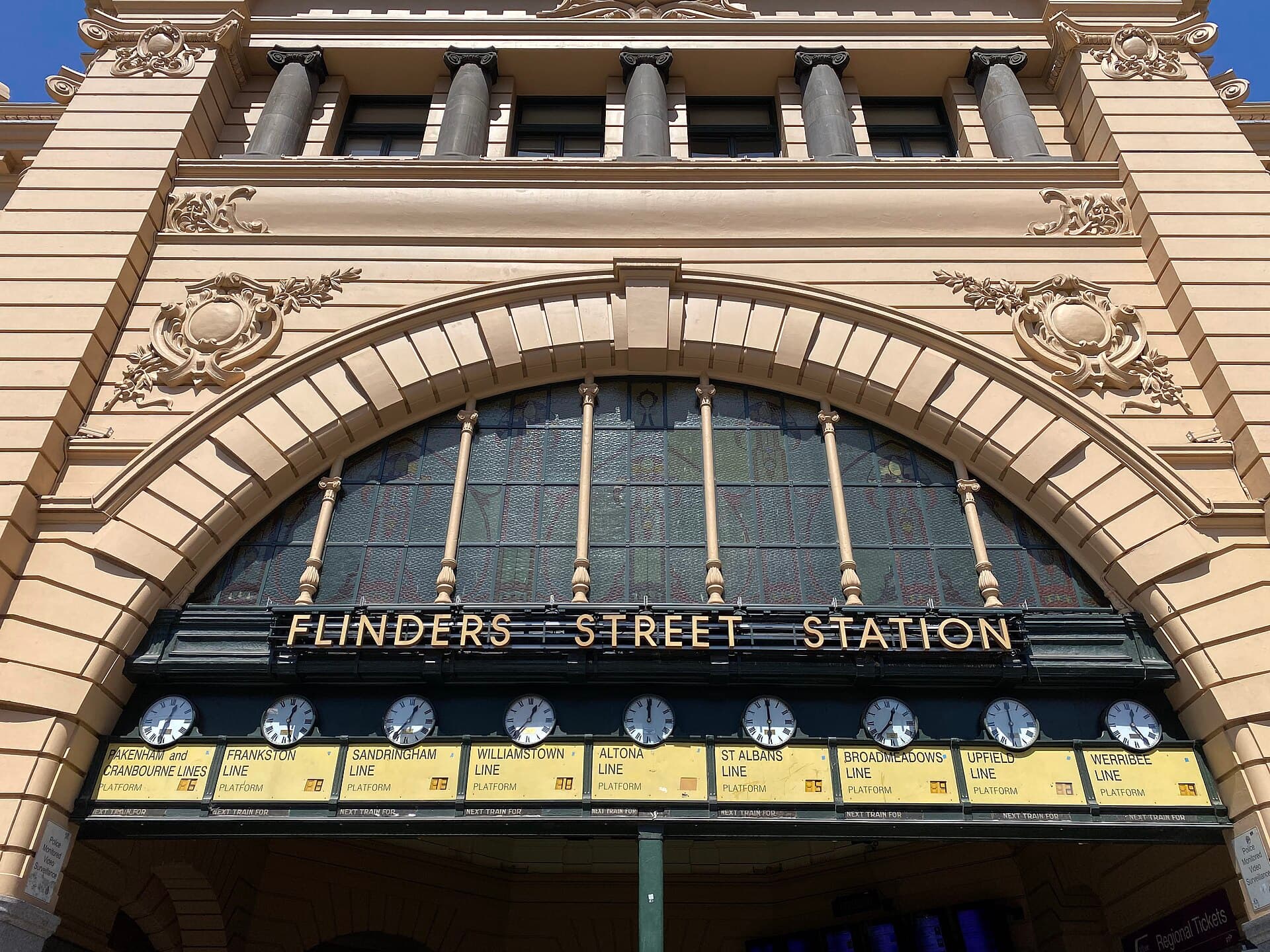 Flinders Street Station's clocks and yellow facade on a busy Melbourne afternoon.